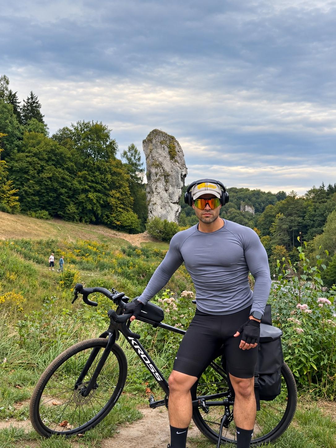 Oğuzhan Berke Özdil standing beside his bicycle in front of Maczuga Herkulesa in Ojców National Park